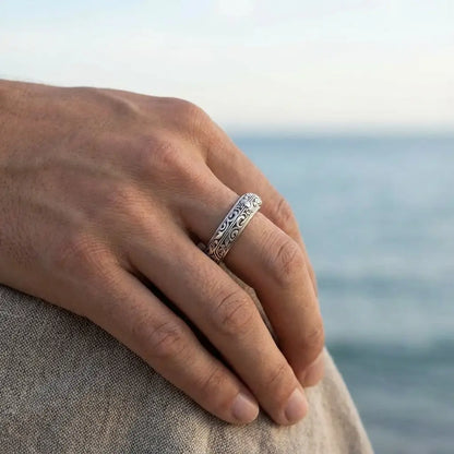 Bague astrale argent portée par un homme face à la mer, alliance de style et de symbolisme.