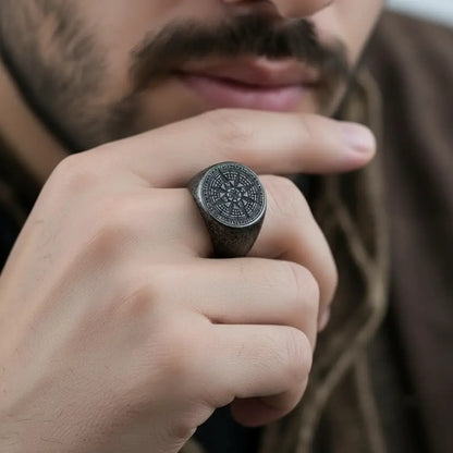 Portrait d’un homme portant la bague boussole argentée, style aventurier et élégant.