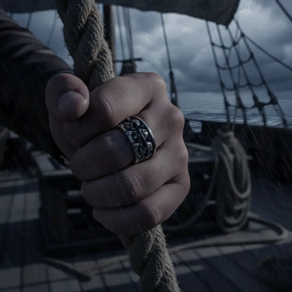 Bague Empire des Crânes portée à la main d’un marin tenant une corde sur un bateau.