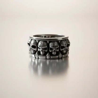 Bague Empire des Crânes présentée sur fond blanc, design massif et détails sculptés.