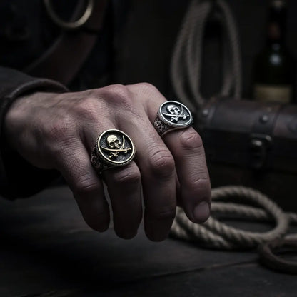 Main d’un pirate portant les deux bagues argent et or du flibustier maudit 316L, ambiance dramatique sombre.