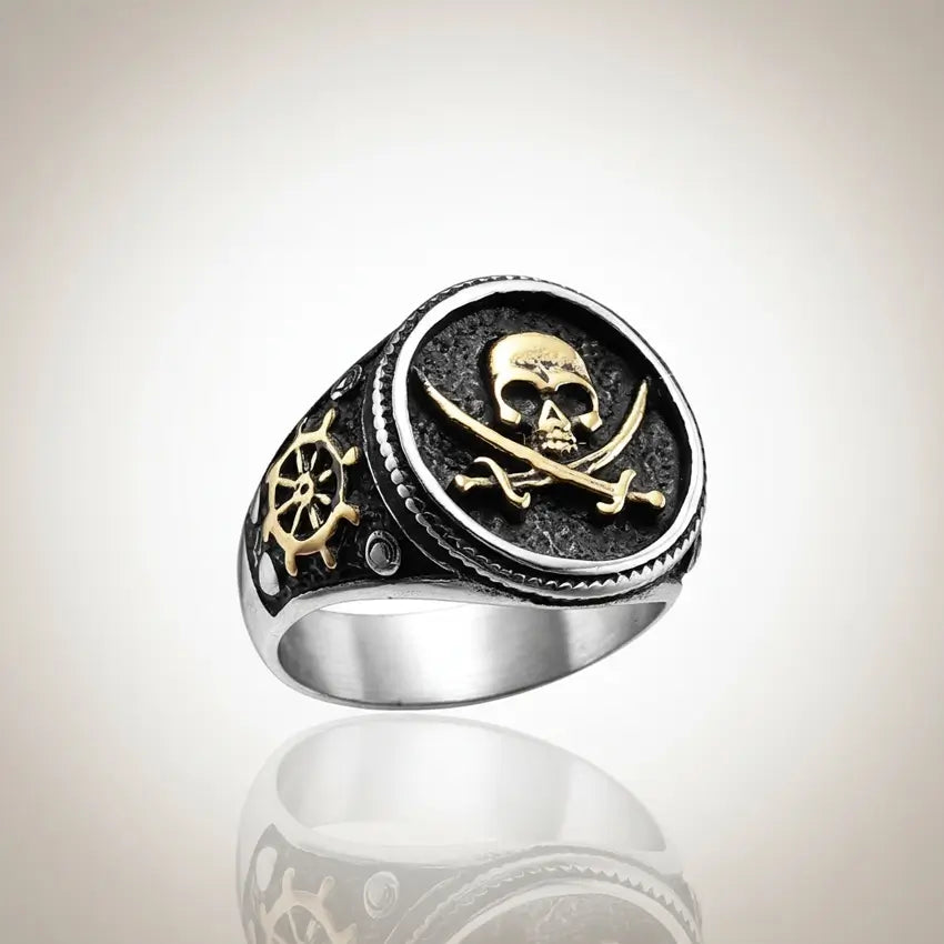 Bague du flibustier maudit en acier 316L avec gravure noire et détails dorés, style pirate sur fond clair.
