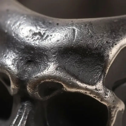 Gros plan sur la texture métallique et les fissures de la bague du Fragment Crânien.