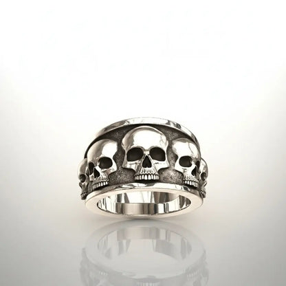 Bague Fraternité des Ombres présentée sur fond blanc, anneau massif et motif de crânes.