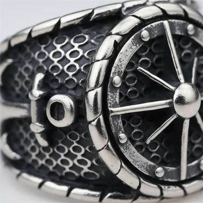 Gros plan sur la gravure de la bague gouvernail du capitaine 316L, texture acier brossé et relief.