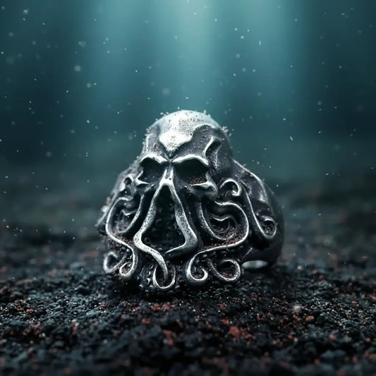 Bague Kraken Impérial posée sur le sable marin dans les profondeurs abyssales.