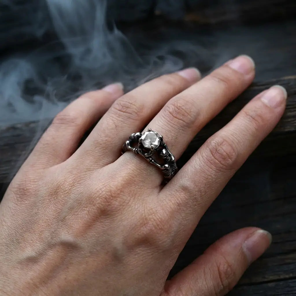 Bague du Pacte Scellé argentée avec la pierre blanche, portée sur les doigts symbole de serment.