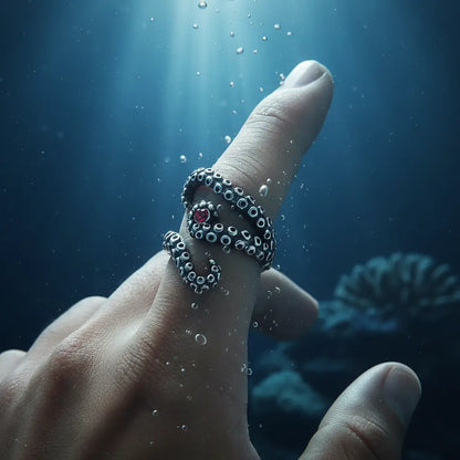 Bague des tentacules argentées portée sur la main dans une ambiance sous-marine.