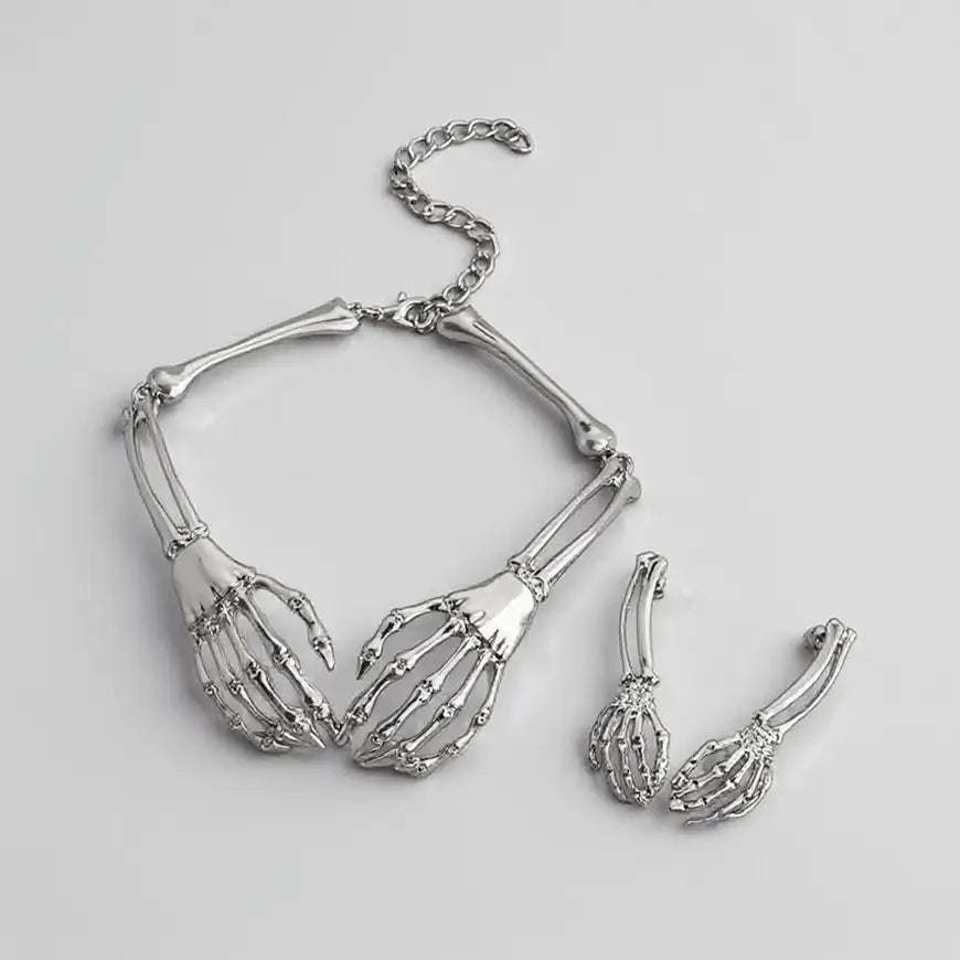 Set de bijoux gothiques argentés composé d’un collier squelette et de boucles d’oreilles assorties.