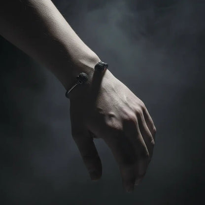 Bracelet du Capitaine Sombre porté au poignet dans une ambiance sombre et brumeuse.