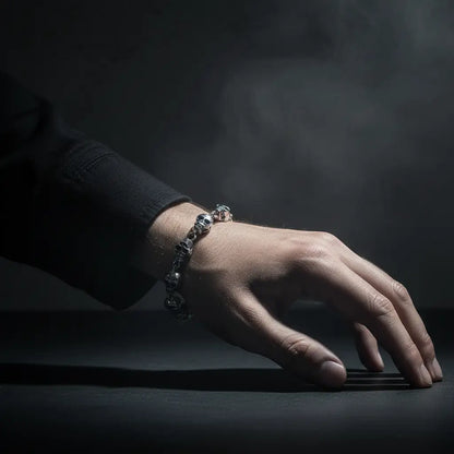 Bracelet Royal des Ombres porté à la main en lumière basse et dramatique.