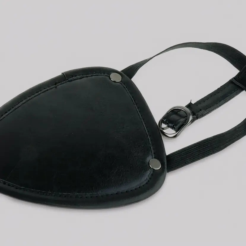 Cache-œil pirate en simili cuir noir, vue rapprochée de l’accessoire de déguisement ajustable sur fond blanc