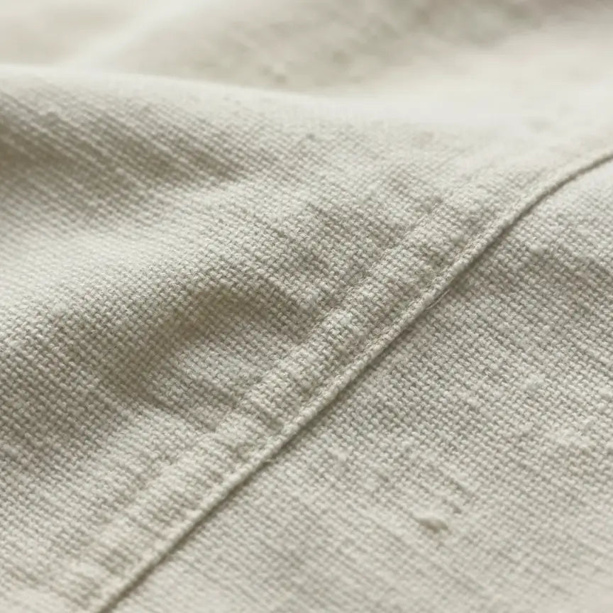 Détail du tissu de la chemise à lacet du capitaine, texture naturelle et robuste.