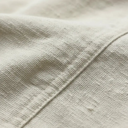 Détail du tissu de la chemise à lacet du capitaine, texture naturelle et robuste.