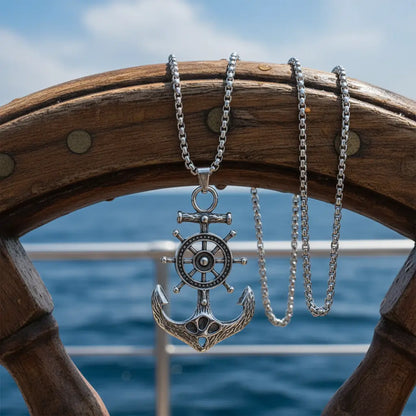 Collier Gouvernail argenté suspendu sur une barre de navigation, ambiance maritime.
