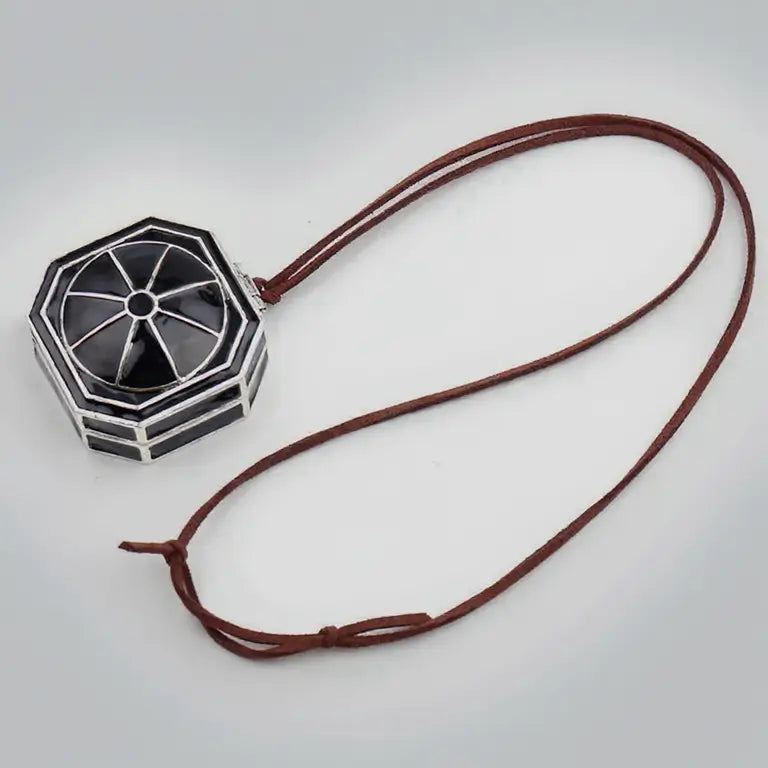 Collier boussole Pirate des Caraïbes complet avec pendentif octogonal argenté et cordon en cuir marron.