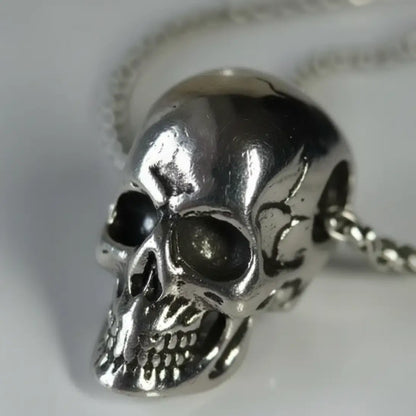 Gros plan sur le visage du pendentif Crâne Brisé au style sombre et usé.