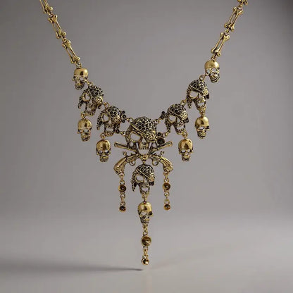 Collier Crâne Maudit doré sur fond clair, bijou pirate de la gamme Ténèbres, orné de crânes et pendentifs croisés.