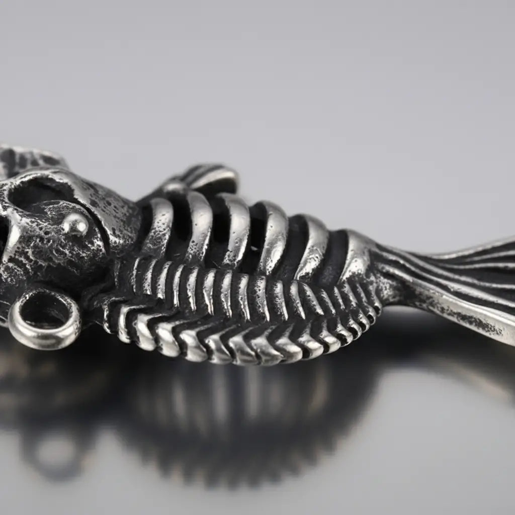 Gros plan sur le pendentif du Collier Poisson Squelette Piranha montrant les détails du métal.