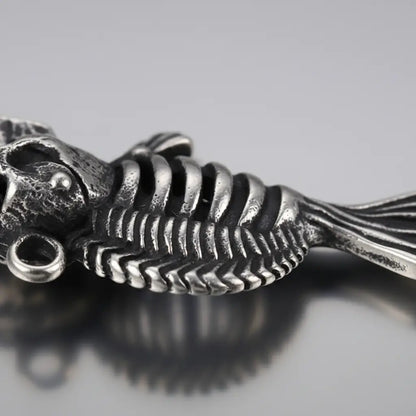 Gros plan sur le pendentif du Collier Poisson Squelette Piranha montrant les détails du métal.