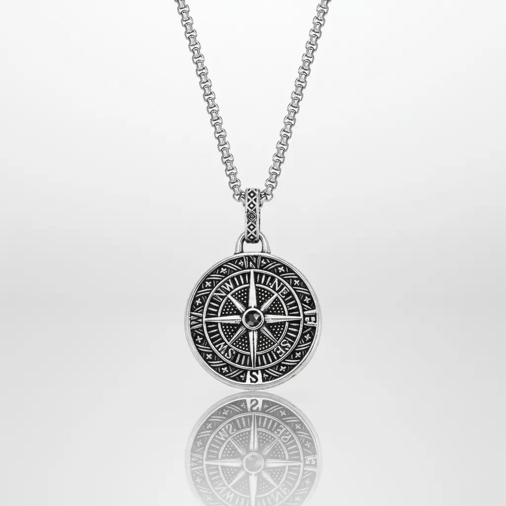 Pendentif Rose des Vents en acier argenté sur fond blanc, bijou raffiné inspiré de l’univers marin et des explorateurs.