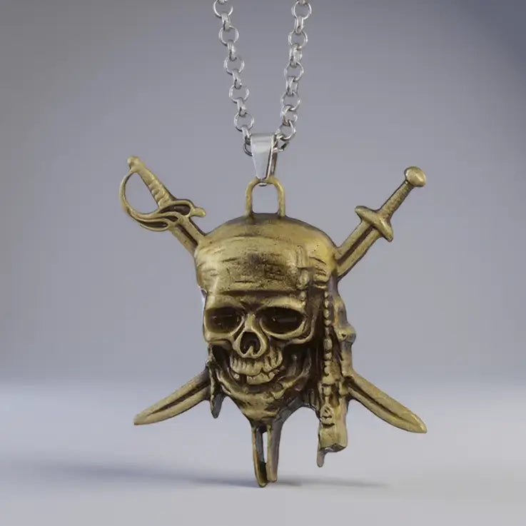 Pendentif pirate en bronze représentant un crâne et deux sabres croisés, collier Sabres du Flibustier sur fond blanc.