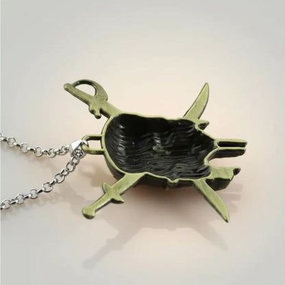 Gros plan sur le face arrière creuse du pendentif sabres flibustier bronze.