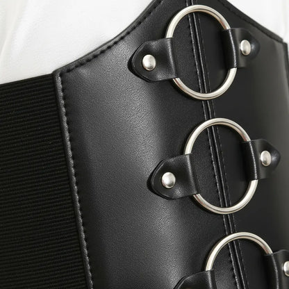 Détail des anneaux métalliques du corset noir aux trois anneaux.
