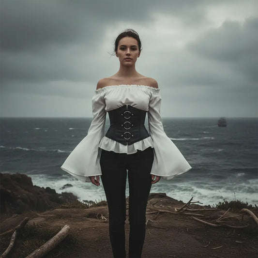 Corset noir aux trois anneaux porté face à la mer, style pirate élégant et affirmé.