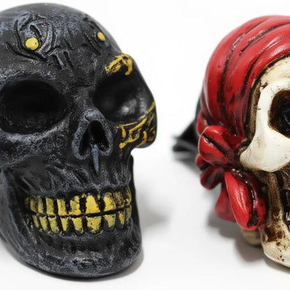 Vue rapprochée du désodorisant crâne pirate en résine noire et rouge, texture réaliste et sombre.