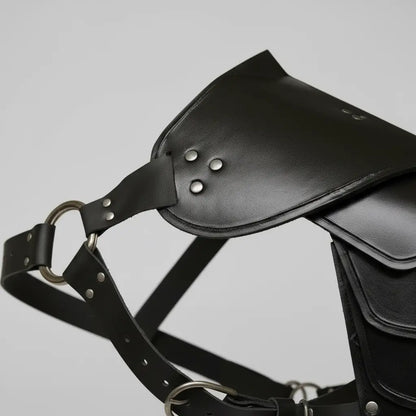 Gros plan sur une épaulette d’armure pirate en cuir noir, vue détaillée des coutures et sangles.