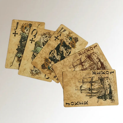 Ensemble de cartes du jeu Pirate Maudit montrant des navires et symboles occultes sur fond blanc.