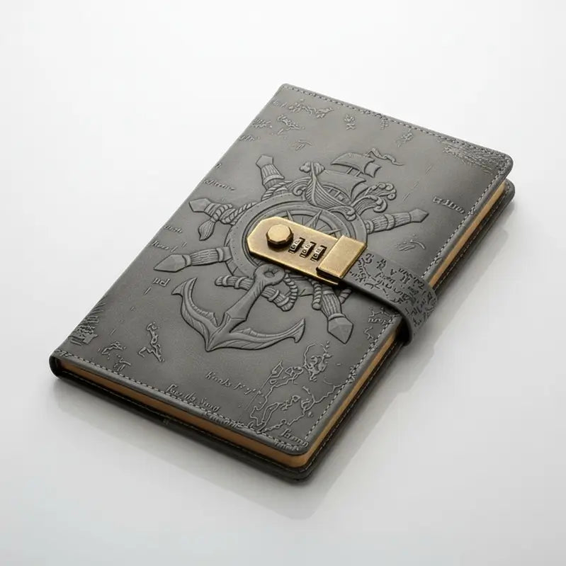Journal pirate en cuir gris foncé avec cadenas à code doré et motifs de boussole embossés.