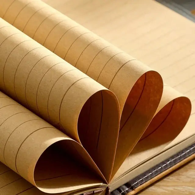 Détail des pages intérieures d’un journal pirate en cuir, papier épais beige enroulé en forme de cœur.