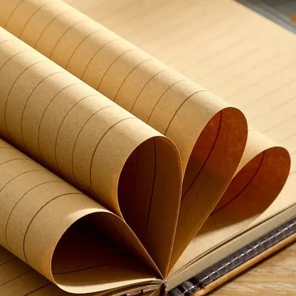 Détail des pages intérieures d’un journal pirate en cuir, papier épais beige enroulé en forme de cœur.