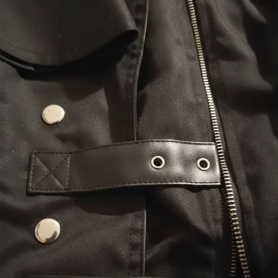 Détail des sangles et boutons métalliques du manteau du Capitaine des Abysses.