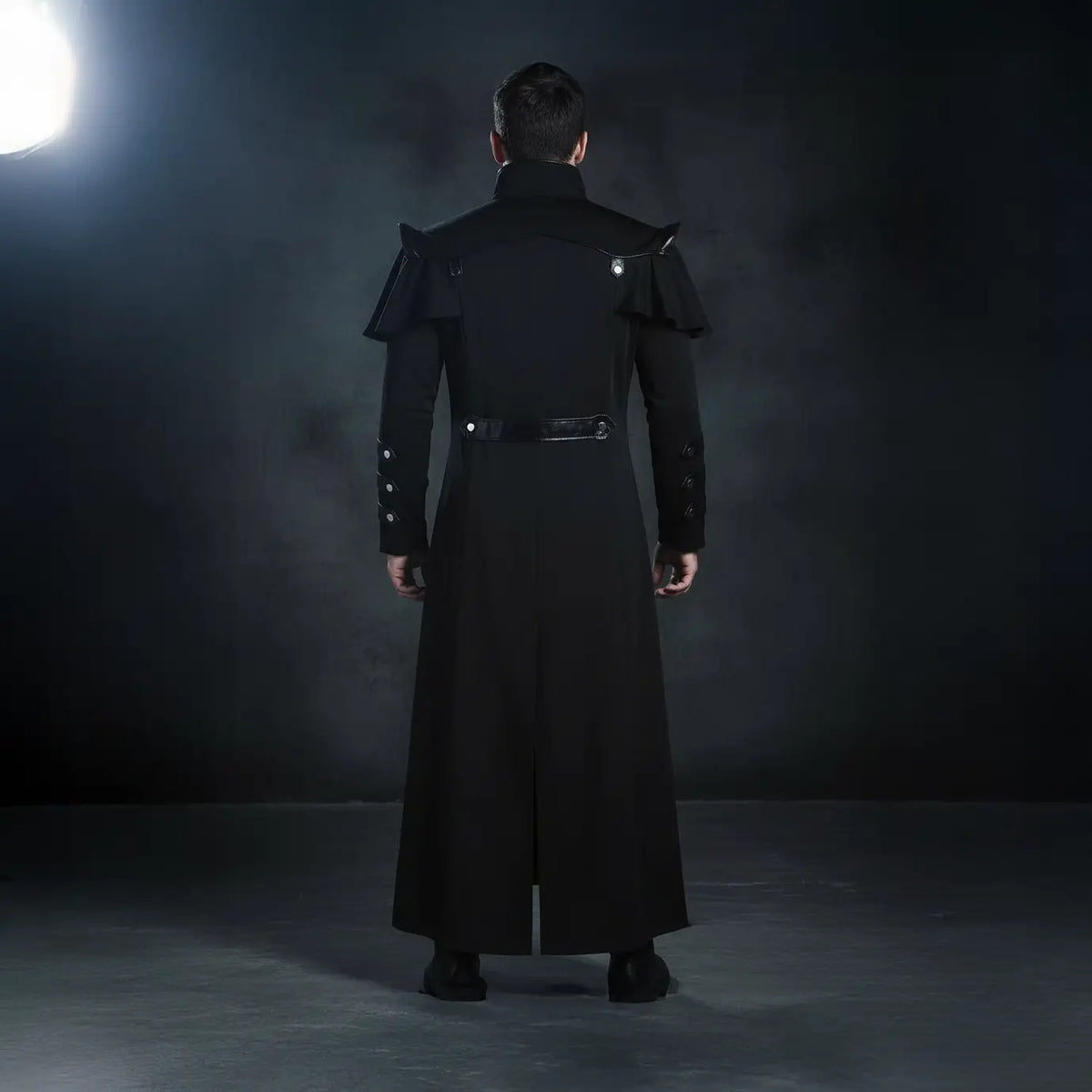 Vue de dos du manteau du Capitaine des Abysses noir, silhouette longue et rigide.