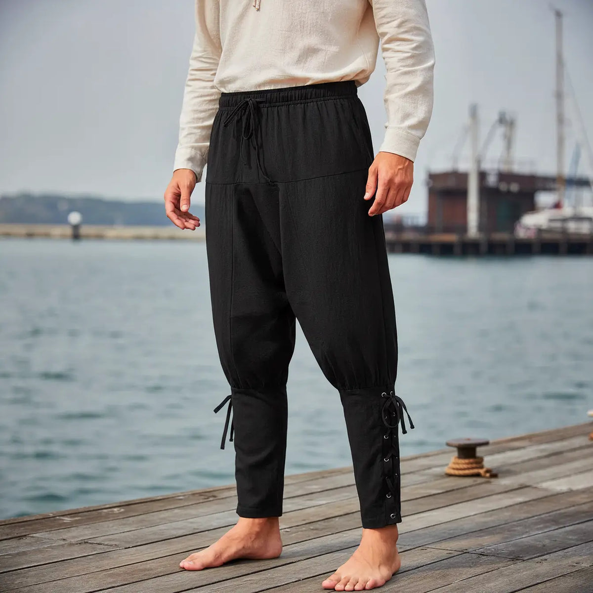 Pantalon du corsaire des mers noir porté sur un quai maritime, ambiance pirate.