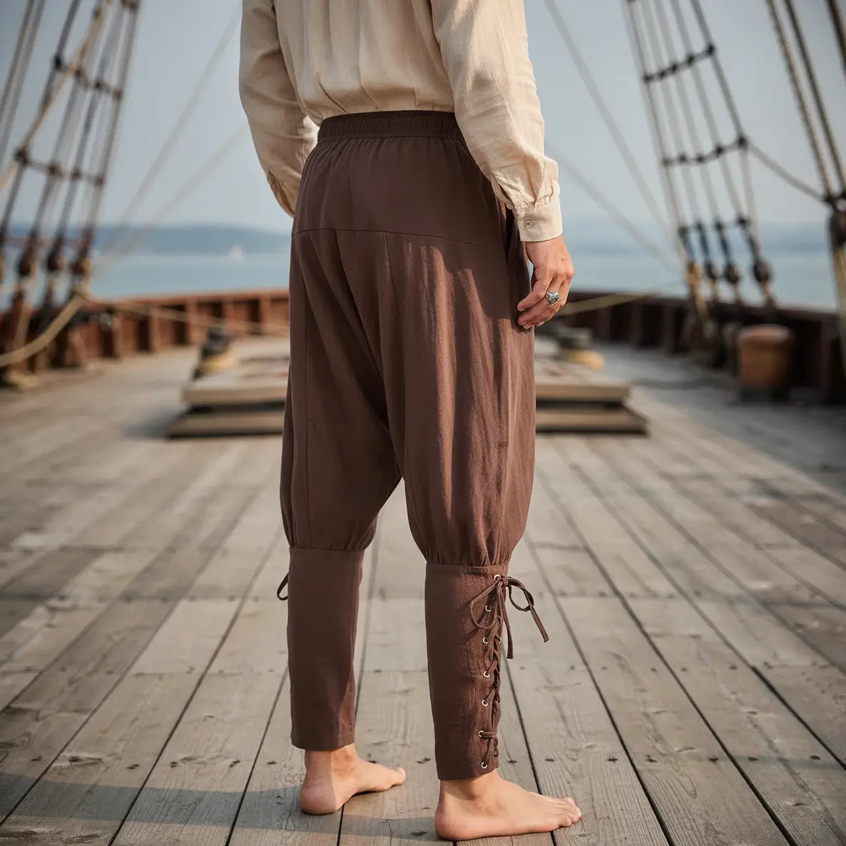 Vue arrière du pantalon du corsaire des mers porté sur le pont d’un navire pirate.