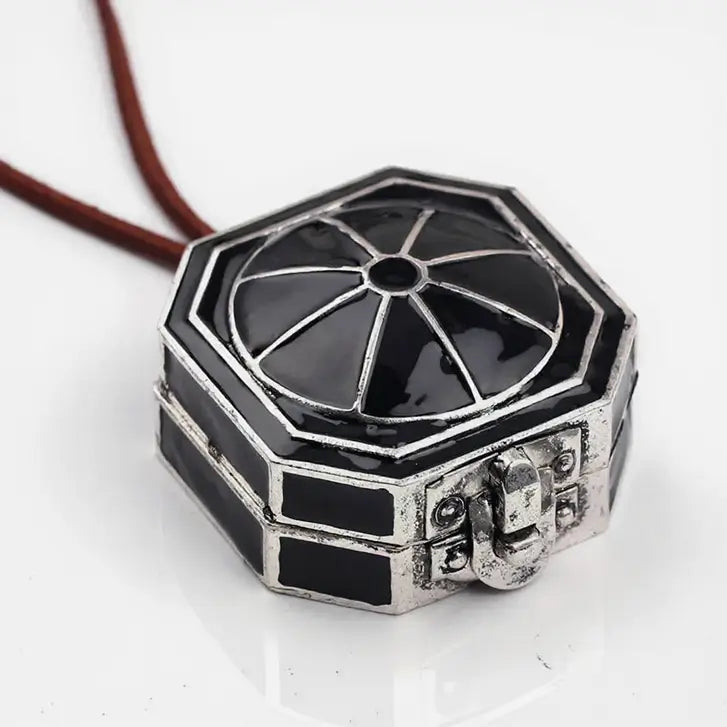 Gros plan sur un pendentif octogonal de style pirate, finition argentée brillante avec détails en relief.
