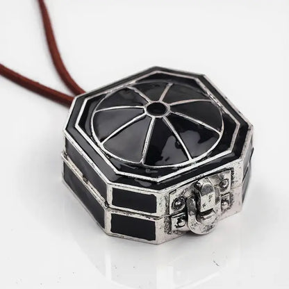 Gros plan sur un pendentif octogonal de style pirate, finition argentée brillante avec détails en relief.