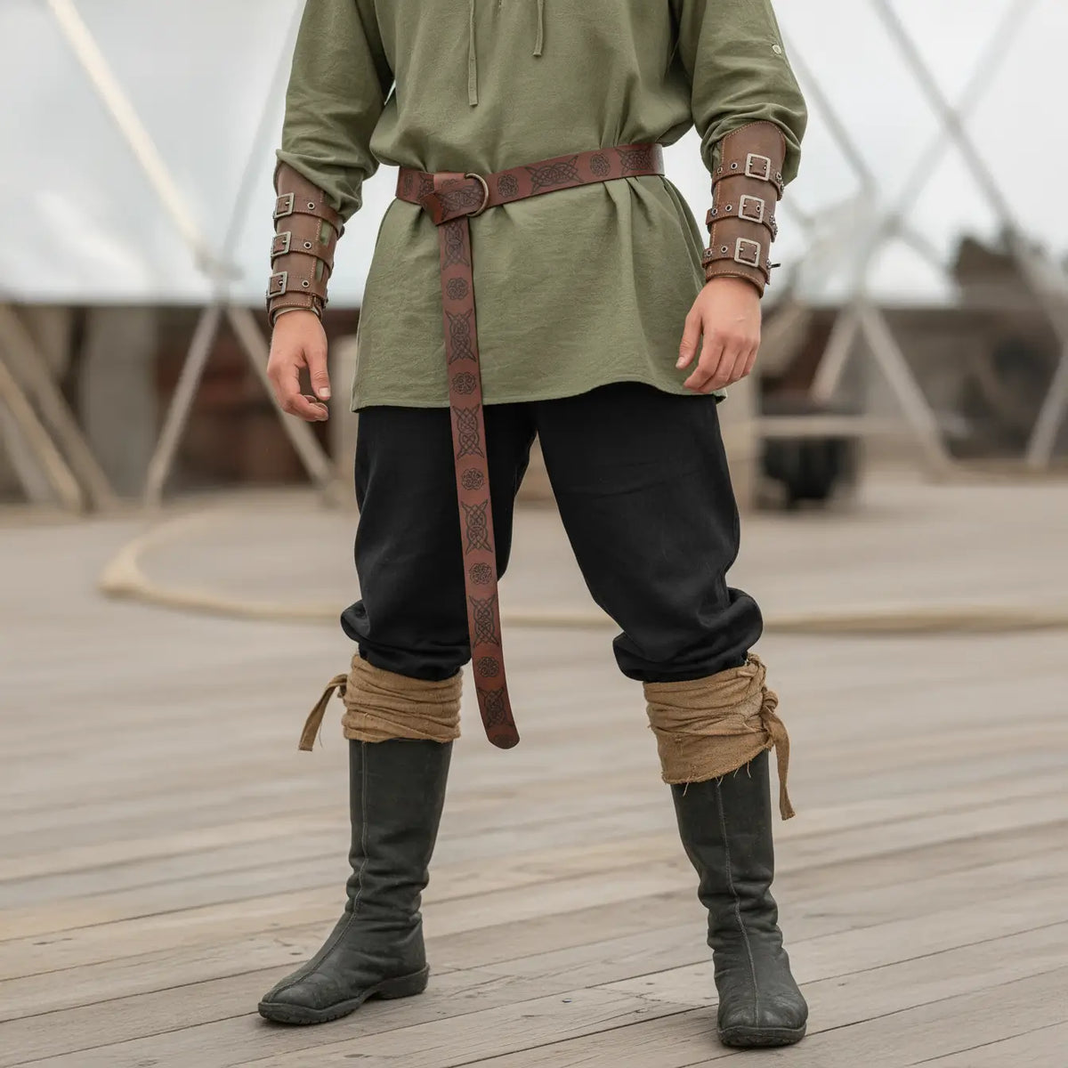Pantalon et bottes de la tenue complète du flibustier portés sur un pont de navire pirate.