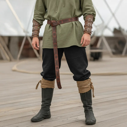 Pantalon et bottes de la tenue complète du flibustier portés sur un pont de navire pirate.