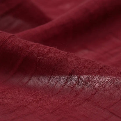 Gros plan sur le tissu rouge bordeaux du bandeau pirate, texture soyeuse et finition réaliste.