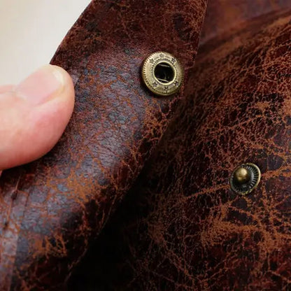 Détail du tricorne du capitaine montrant la texture du cuir vieilli et le bouton métallique doré.
