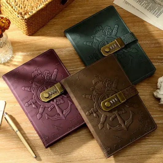 Trois journaux pirates en cuir de plusieurs couleurs avec cadenas à code, présentés sur une table rétro.