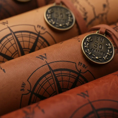 Gros plan sur le cuir gravé de la trousse carte au trésor, motif de boussole et texture soignée.