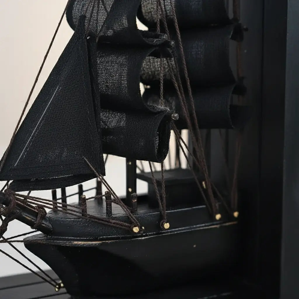 Gros plan sur le navire noir du cale-livre Navire Fantôme, détails des voiles et cordages.